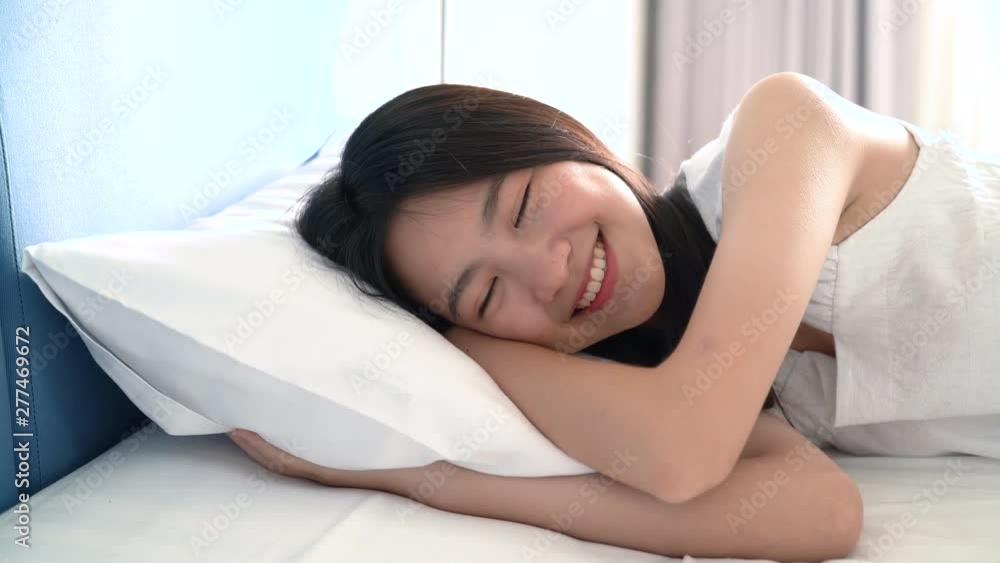 Beautiful Asian woman smiling happy in the bed her lying under blanket in bedroom cozy comfortable resting at hotel room people healthy lifestyle in the morning. Beautiful Asian woman smiling happy in the bed her lying under blanket in bedroom cozy comfortable resting at hotel room people healthy lifestyle in the morning.