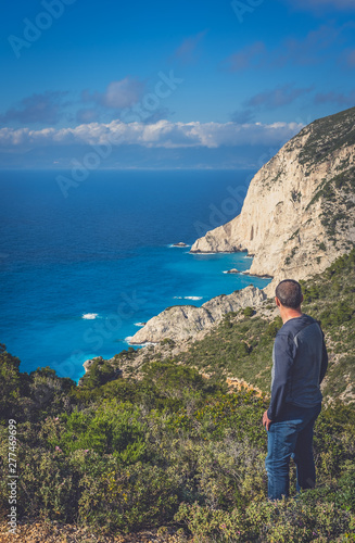 Tourist admiring view on the viewpoint above Navagio Beach