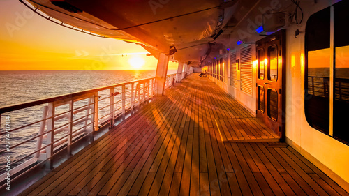 Pont promenade d'un navire de croisière en navigation avec coucher de soleil. photo