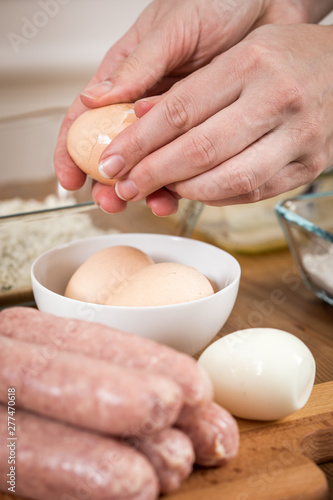 Frau pellt Eier für Scotch Eggs in Schweine Fleisch Wurstbrät und Paniermehl  photo