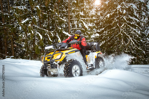 Winter race on an ATV on snow in the forest.