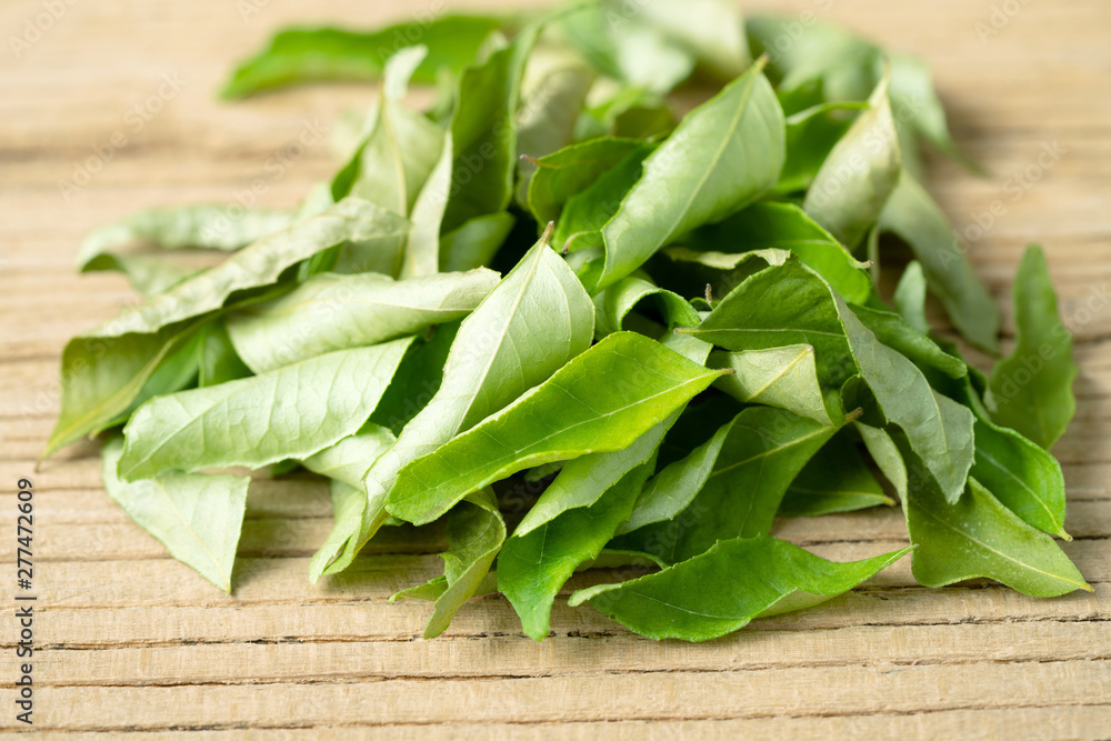 dried curry tree leaves on the wooden board dried curry tree leaves on the wooden board