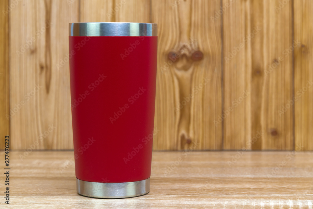 Red colour stainless steel tumbler or cold and hot storage cup on wood. Red colour stainless steel tumbler or cold and hot storage cup on wood.