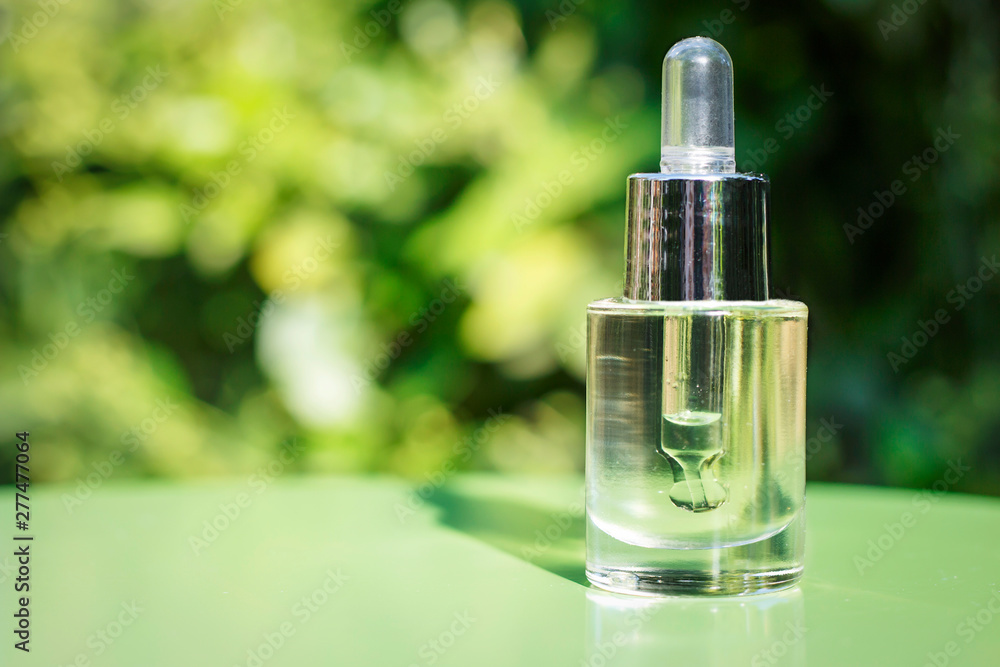 Serum and dropper on a green background close-up, natural cosmetics concept Serum and dropper on a green background close-up, natural cosmetics concept