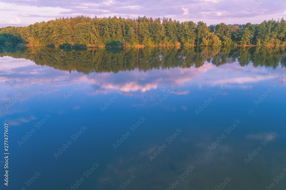 Fototapeta premium The magical sunrise over the lake. Rural landscape