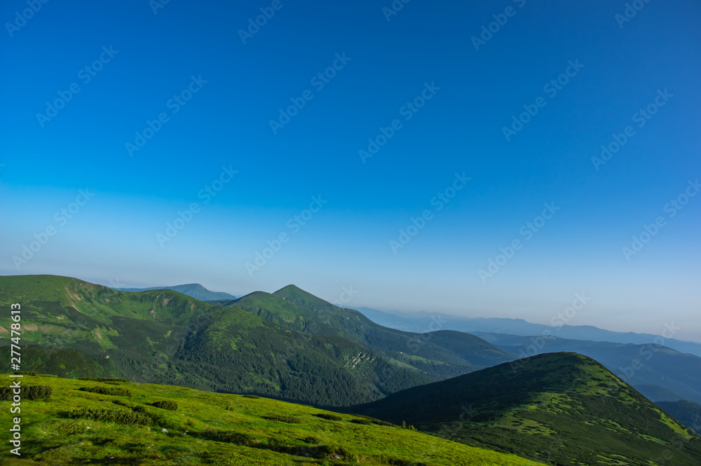 Green hills against the blue sky in the mountains