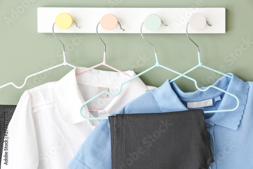 Stylish school uniform hanging on wall © Pixel-Shot