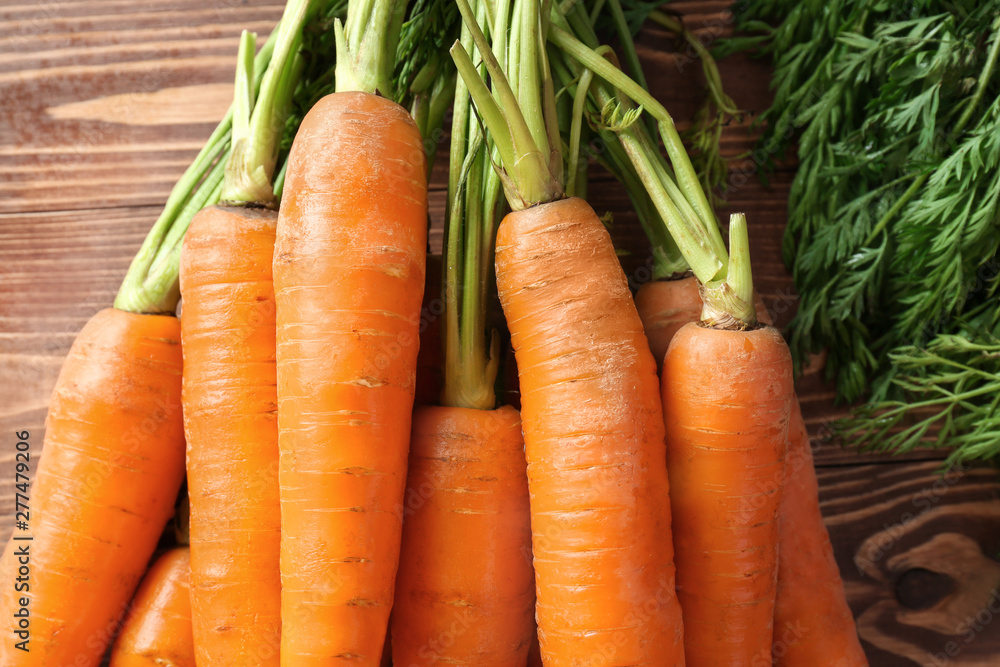 Tasty fresh carrot on wooden background, closeup Tasty fresh carrot on wooden background, closeup