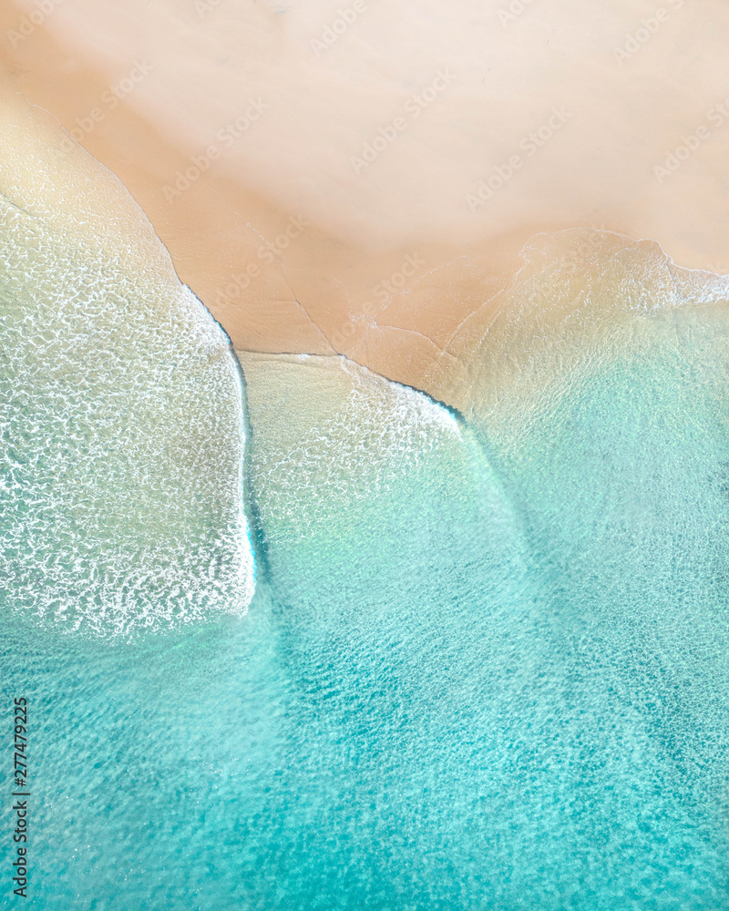 Fototapeta Aerial of a beach with beautiful waves, white sand and ocean textures