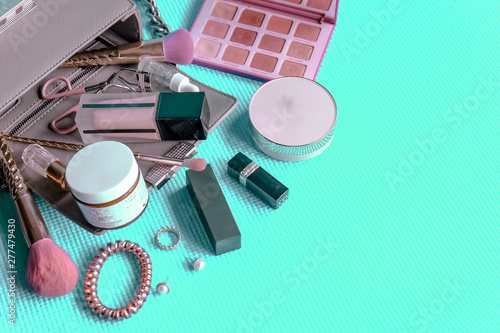 Set of Makeup cosmetics products with bag on green pastel background
