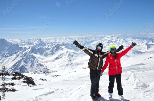 Young couple in snowboarding helmets standing at caucasus mountains, Elbrus