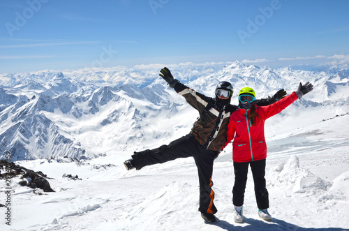 Young couple in snowboarding helmets standing at caucasus mountains, Elbrus