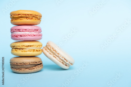 Fototapeta Naklejka Na Ścianę i Meble -  Colorful almond cookies, cake macaron or macaroon on blue background. Place for text