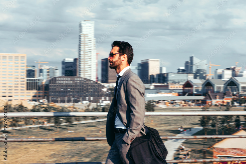 confident and elegant man walking on the street on metropolitan city background. fashion, male, city, lifestyles concept confident and elegant man walking on the street on metropolitan city background. fashion, male, city, lifestyles concept