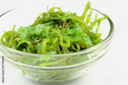 wakame salad with sesame in a small glass bowl isolated