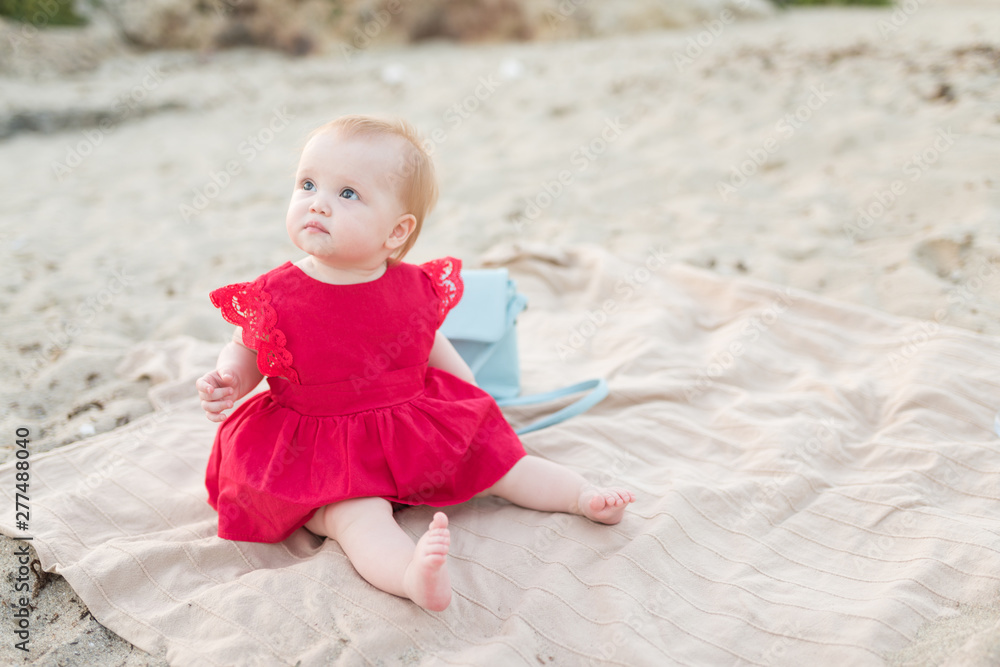 Beautiful little baby girl sitting on the beach Beautiful little baby girl sitting on the beach