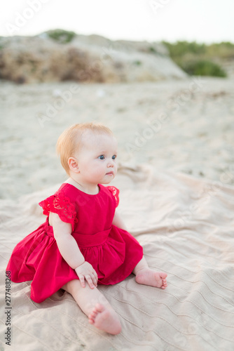 Beautiful little girl sitting on the beach © Konstantin Maslak