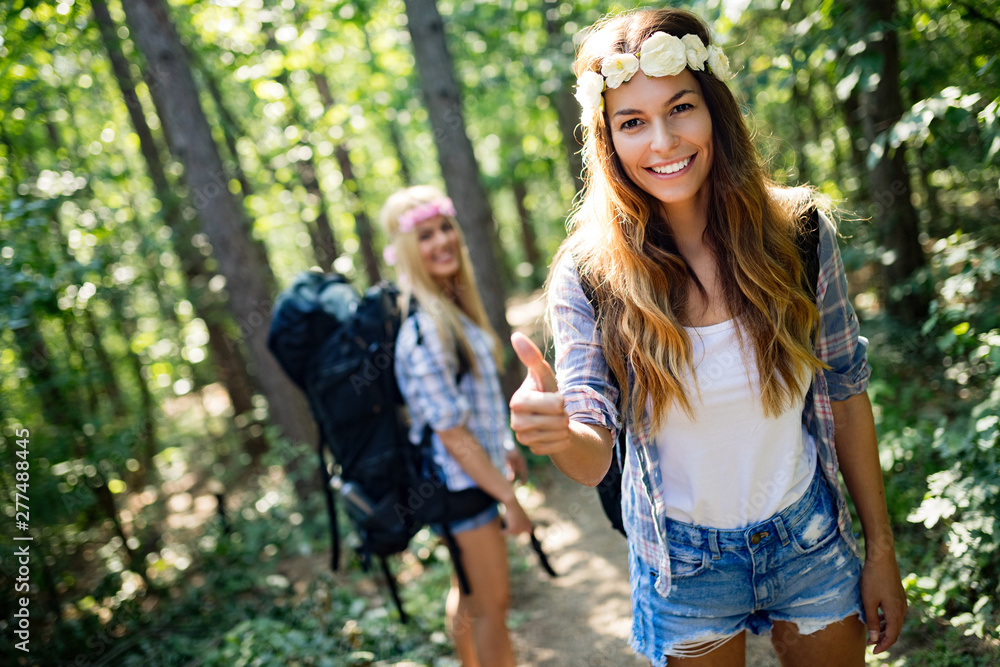 Adventure, travel, tourism, hike and people concept. Happy woman walking with backpacks in woods