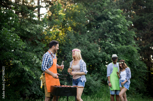 Group of friends making a barbecue together outdoors in the nature
