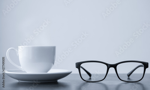 Coffee cup and glasses on desk