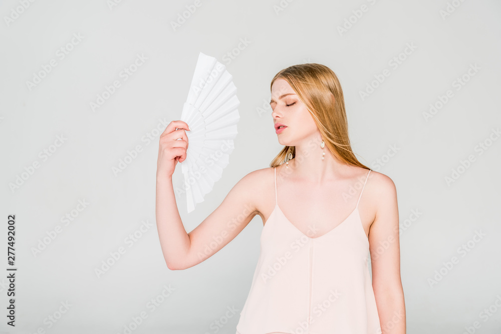 beautiful young woman with hand fan suffering from heat on grey beautiful young woman with hand fan suffering from heat on grey