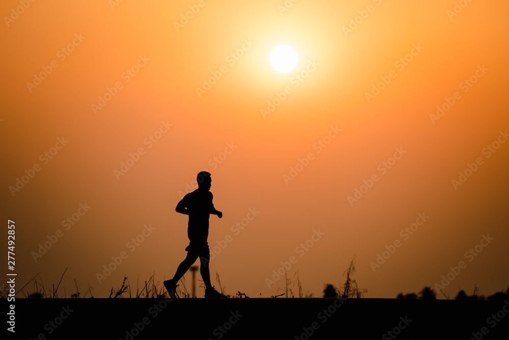 Silhouette man running on sunset background