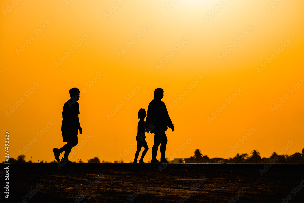 man and woman walking on sunset background