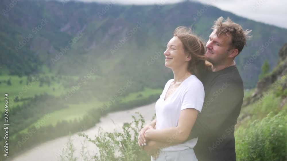Couple in love on the top of the mountain. A man embraces a woman from ...