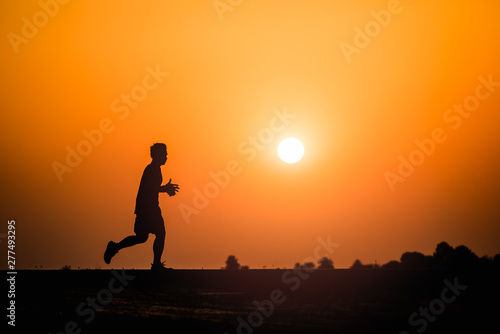 Fototapeta Naklejka Na Ścianę i Meble -  Silhouette man running on sunset background