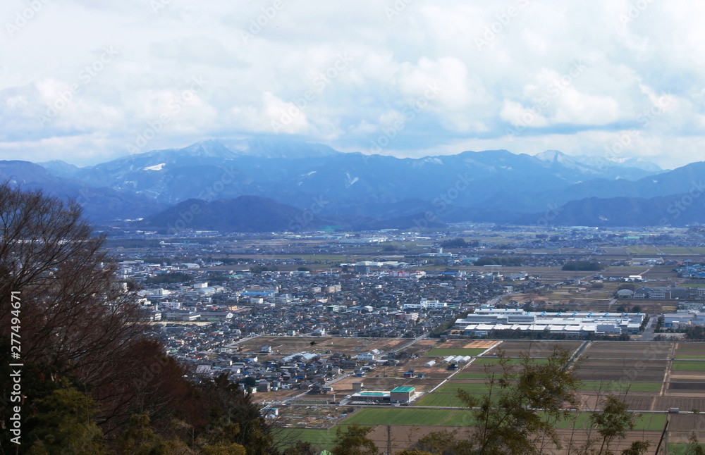 俯瞰で見る滋賀県彦根市の町並みと雪山の風景
