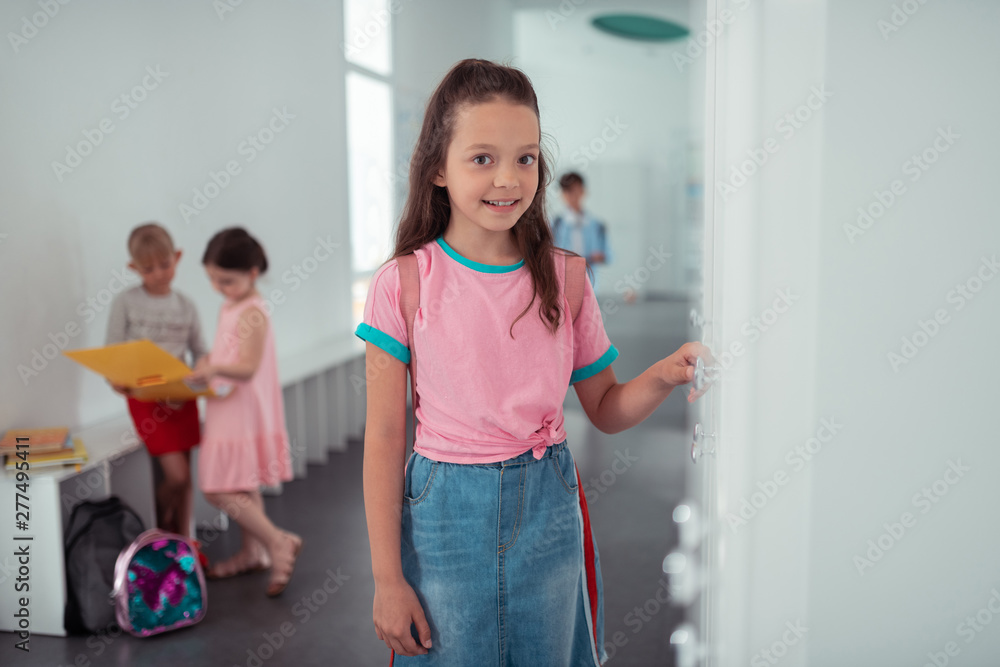 Dark-eyed girl feeling excited before first day at new school Dark-eyed girl feeling excited before first day at new school