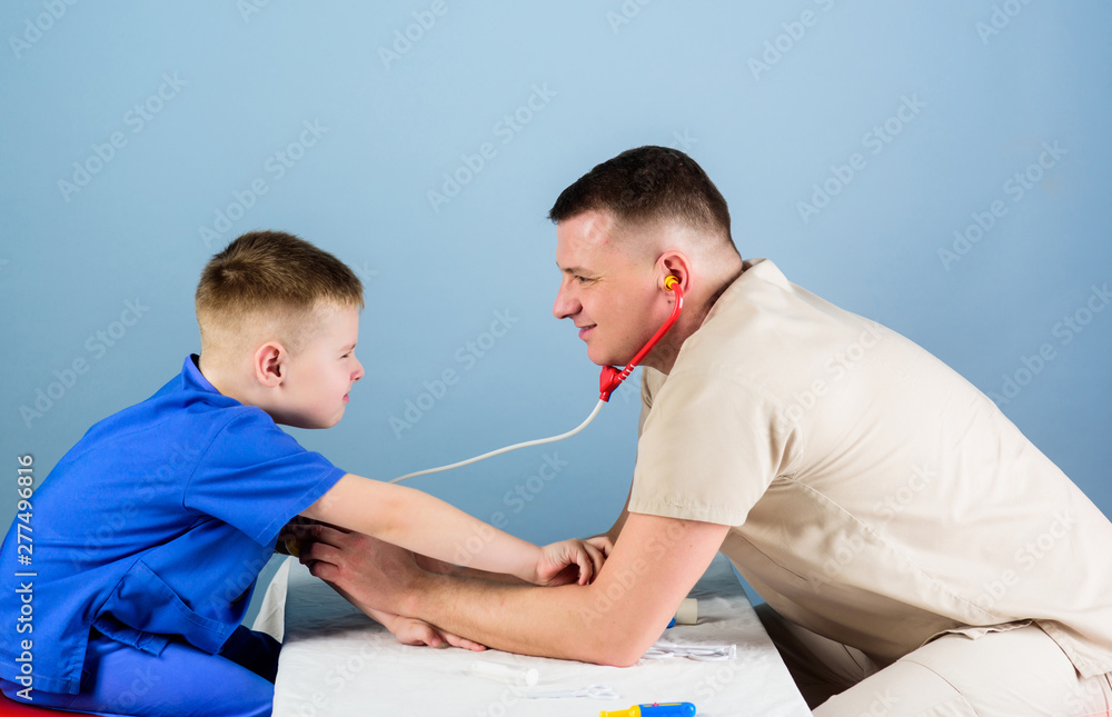 Man doctor sit table medical tools examining little boy patient. Health care. Pediatrician concept. Careful pediatrician check health of kid. Medical examination. Hospital worker. Medical service Man doctor sit table medical tools examining little boy patient. Health care. Pediatrician concept. Careful pediatrician check health of kid. Medical examination. Hospital worker. Medical service