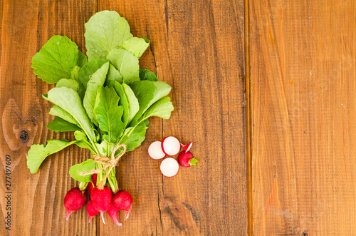 Bunch of fresh radish on brown wooden table. 