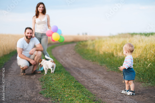 Happy family portrait. Mother, father, son and their dog enjoy time together playing outdoors. People and pets, lifestyle concept