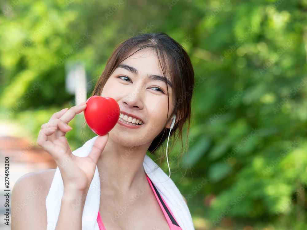 Close up of Beautiful Asian girl in sportswear Happy and smile holding heart in hand after jogging. In the morning at garden. healthy exercise Concept Close up of Beautiful Asian girl in sportswear Happy and smile holding heart in hand after jogging. In the morning at garden. healthy exercise Concept