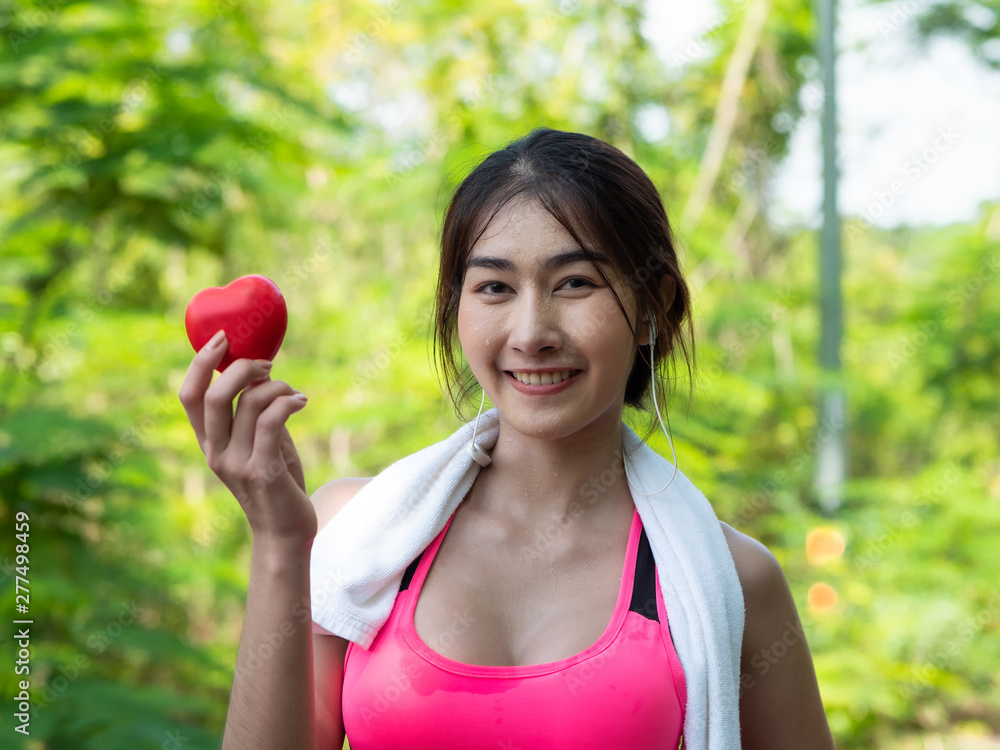 Close up of Beautiful Asian girl in sportswear Happy and smile holding heart in hand after jogging. In the morning at garden. healthy exercise Concept Close up of Beautiful Asian girl in sportswear Happy and smile holding heart in hand after jogging. In the morning at garden. healthy exercise Concept