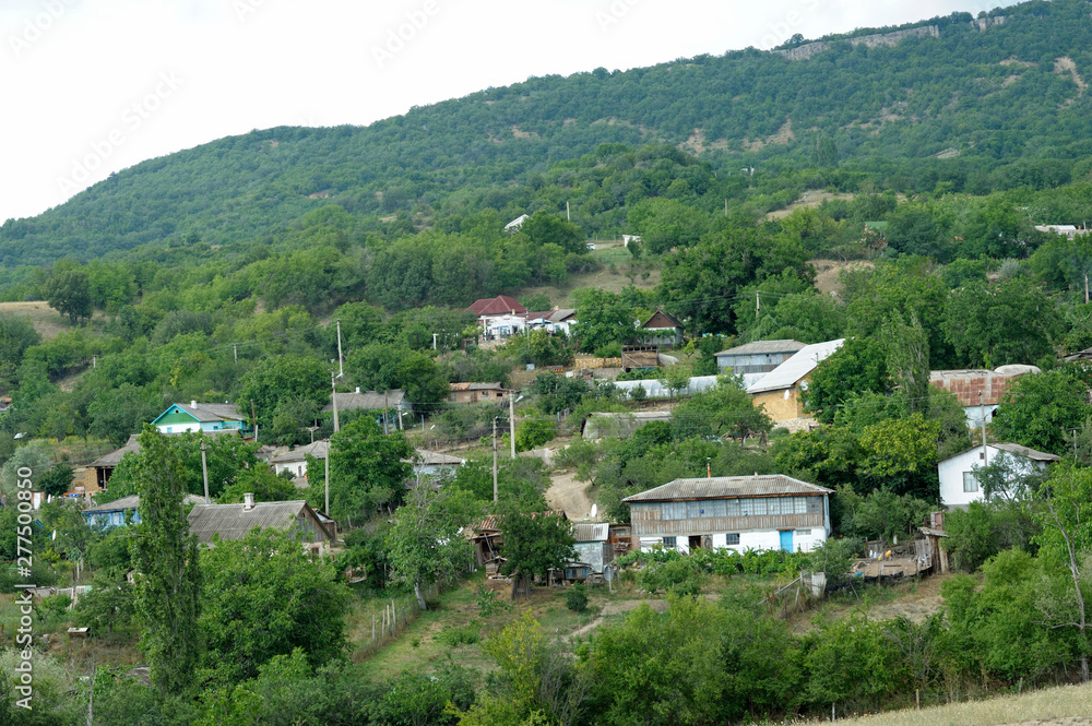 View of country houses and gardens on mountains hills, trees and bushes. Rossoshanka village, Crimea,Ukraine