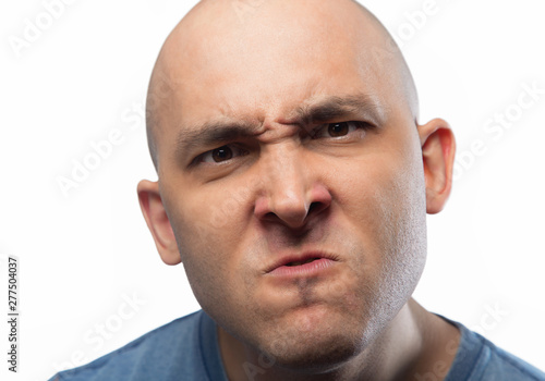 Portrait of the angry frowning bald man