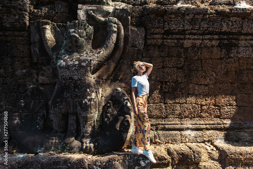 Young female tourist traveler is posing at Angkor Wat temple, Siem Reap, Cambodia photo