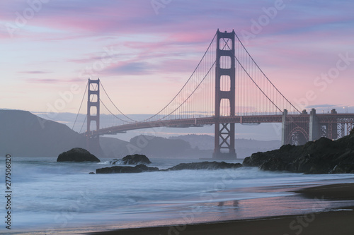 Classic panoramic view of famous Golden Gate Bridge seen from scenic Baker Beach in beautiful golden evening light on sunset with blue sky and clouds in summer, San Francisco, California, USA