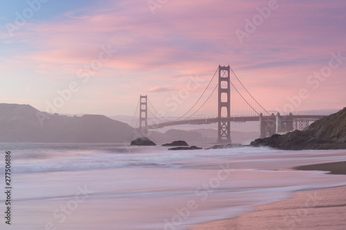 Classic panoramic view of famous Golden Gate Bridge seen from scenic Baker Beach in beautiful golden evening light on sunset with blue sky and clouds in summer  San Francisco  California  USA