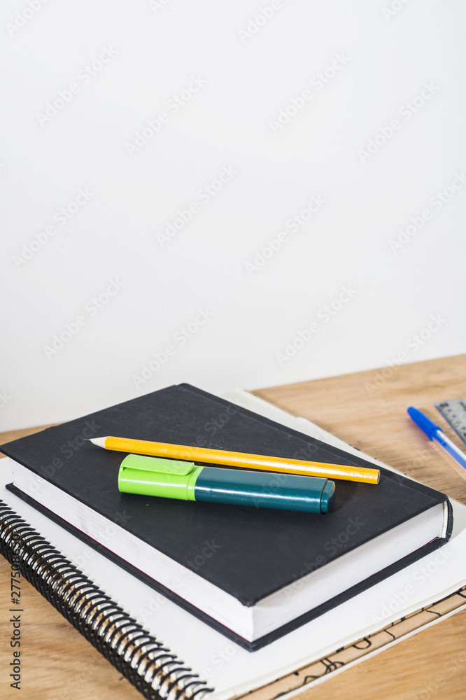 Pencil and highlighter on book and notepad Pencil and highlighter on book and notepad