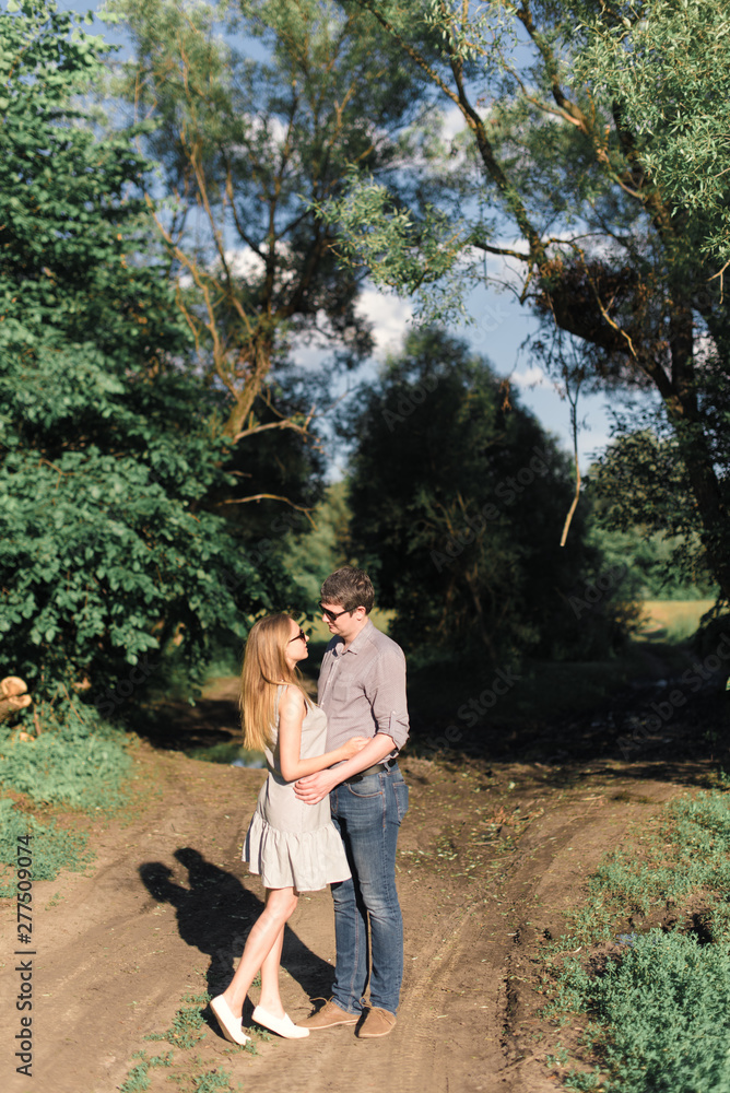 young couple in love on nature at sunset