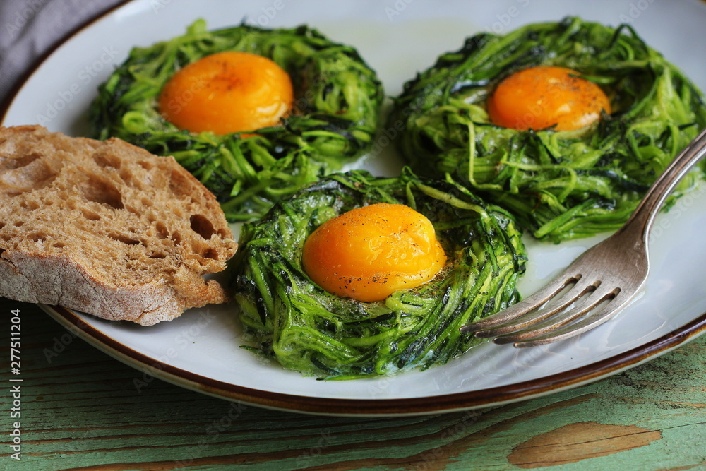 Fried egg in zucchini noodle nest, healthy breakfast, top view Fried egg in zucchini noodle nest, healthy breakfast, top view