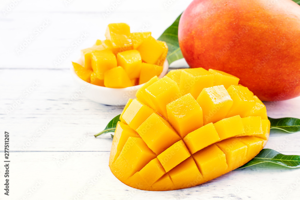 Beautiful chopped mango with green leaves on bright white color timber background. Above Top view, flat lay, copy space, close up. Tropical fruit concept. Beautiful chopped mango with green leaves on bright white color timber background. Above Top view, flat lay, copy space, close up. Tropical fruit concept.