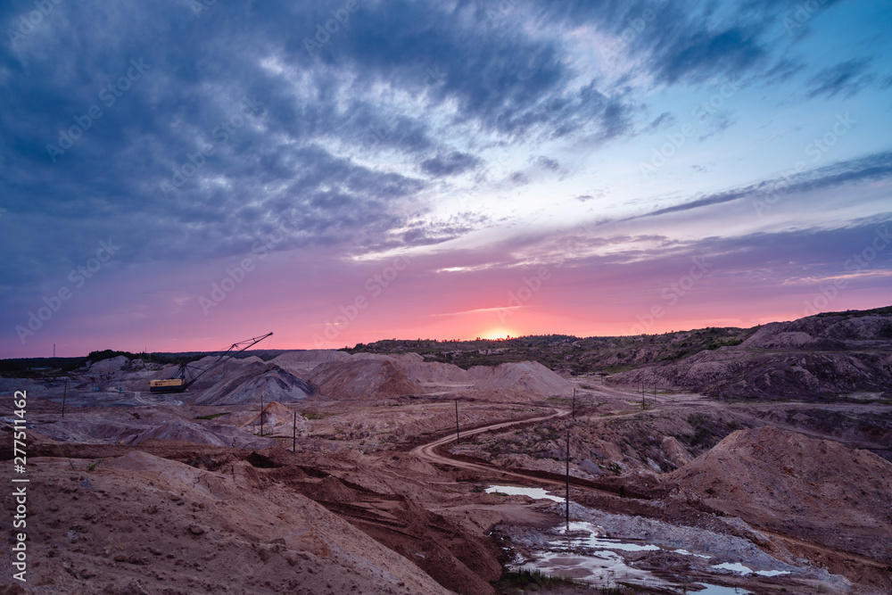 Coal mining at an open pit at sunset
