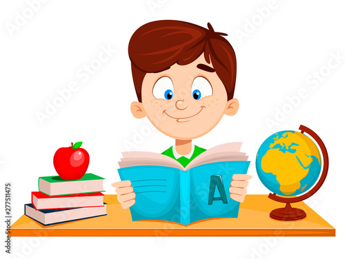 Cute boy sitting at the table and reading ABC book