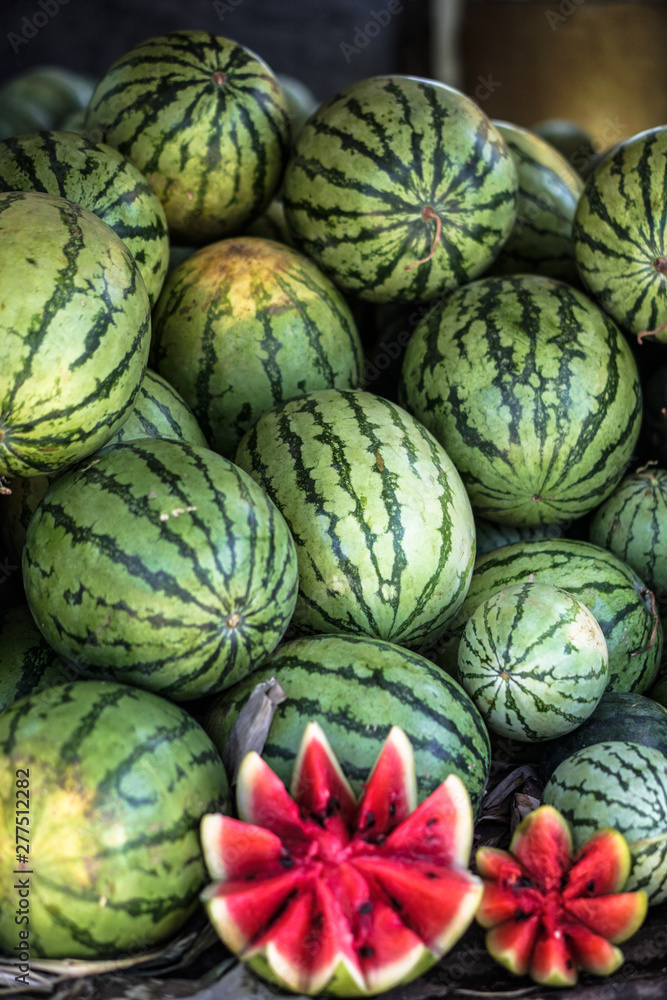 Watermelons and melons are sold on the market in Asia. Sale of vegetarian fruits outdoors. Stock photos Watermelons and melons are sold on the market in Asia. Sale of vegetarian fruits outdoors. Stock photos