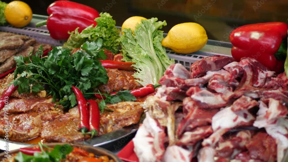 Raw meat beef and chicken with seasoning decorated with red pepper and parsley leaves in counter of store Raw meat beef and chicken with seasoning decorated with red pepper and parsley leaves in counter of store