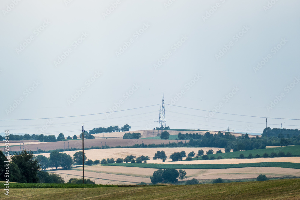 Fototapeta premium Strommasten ziehen sich durchs Feld